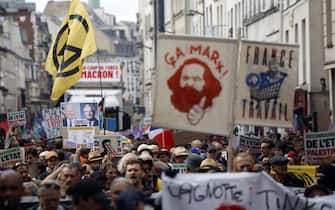 epa11591330 People attend a protest rally in Paris, France, 07 September 2024 as the French left parties called for rallies against President Macron's politics. Protests are taking place across France over the appointment of Michel Barnier as the new French prime minister, after the election that resulted in a National Assembly without a majority and in which the left won the largest number of seats. The poster reads "France work''.  EPA/YOAN VALAT