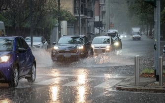 Persone si riparano dalla pioggia con un ombrello durante un temporale a Milano, 5 settembre 2024.
ANSA/MATTEO CORNER