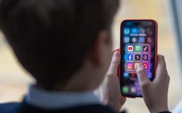 BATH, UNITED KINGDOM - FEBRUARY 25: In this photo illustration a a 12-year-old school boy looks at a iPhone screen A 12-year-old boy looks at an iPhone screen showing various social media apps including TikTok, Facebook and X on February 25, 2024 in Bath, England. This week the UK government issued new guidance backing headteachers in prohibiting the use of mobile phones throughout the school day, including at break times. Many schools around the country are already prohibiting mobile phone use over concerns. The amount of time children spend on screens each day rocketed during the Covid pandemic by more than 50 per cent, the equivalent of an extra hour and twenty minutes. Researchers say that unmoderated screen time can have long-lasting effects on a child's mental and physical health. Recently TikTok announced that every account belonging to a user below age 18 have a 60-minute daily screen time limit automatically set. (Photo by Matt Cardy/Getty Images)