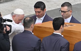 Pope Francis pays his respect as he touch the coffin of Pope Emeritus Benedict XVI during his funeral mass at St. Peter's square in the Vatican, on January 5, 2023. - Pope Francis is presiding on January 5 over the funeral of his predecessor Benedict XVI at the Vatican, an unprecedented event in modern times expected to draw tens of thousands of people. (Photo by Alberto PIZZOLI / AFP) (Photo by ALBERTO PIZZOLI/AFP via Getty Images)