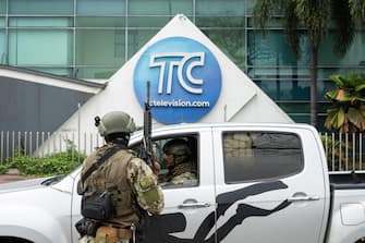 epa11066667 Marines carry out an operation at the headquarters of TC television station where armed, hooded men entered and subdued staff during a live broadcast, in Guayaquil, Ecuador, 09 January 2024. Agents of the National Police of Ecuador arrested at least thirteen people after entering the facilities of TC Television hours after a group of heavily armed men interrupted live programming, threatening employees with rifles, grenades and explosives.  EPA/Mauricio Torres