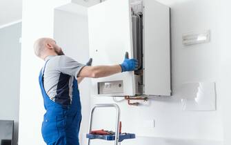 Professional engineer doing a boiler inspection at home