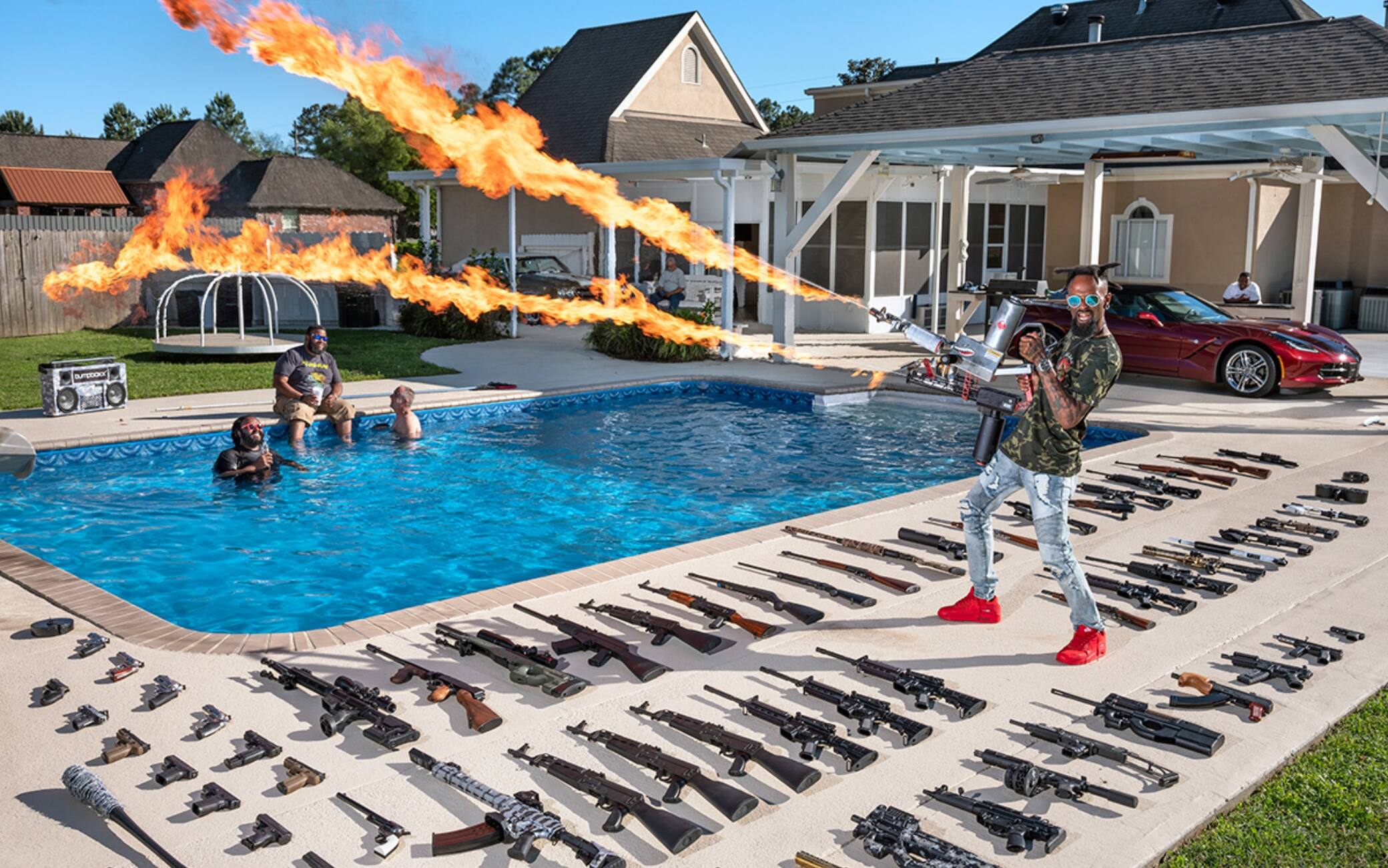 Torrell Jasper, a.k.a. Black Rambo (35) – Schiever, Louisiana
(in the background, Allen Craff, Tyrone Gathen, James J. Herbert)

Every day, nearly six hundred thousand people wait for Torrell Jasper to make his appearance on Instagram and show off one of his guns. To find him, just type in “Black Rambo,” a nickname he’s extremely proud of, and make sure you don't end up on his son’s account by mistake (at 13, he’s already trying to make a name for himself on social media). Torrell, now 35, learned to shoot from his father as a child. A former Marine, he spent a few years in war zones, “where pulling the trigger and hitting the target was a question of life or death.” Now, back in civilian life and working as an A/C systems installer, Torrell, a.k.a. Black Rambo, mostly just has fun with his guns. People have fun watching him, too. About a hundred different manufacturers of firearms and related paraphernalia have, over the years, asked him to use and promote their products, and he loves being the center of attention at least as much as he loves owning a flamethrower. “There are no weapons I would ban ordinary citizens from owning, but if I had to name one, well, a bazooka isn't really something you need,” he admits. That said, he has no fear that an item in his arsenal might be dangerous for his young children or for any of his many followers. “It’s not guns that hurt people, it’s the people holding the guns.” 

I couldn’t say which weapon is my favorite. I can’t choose just one. I love them all. That’s why I buy so many. 


The first gun I ever bought was an AK-47.