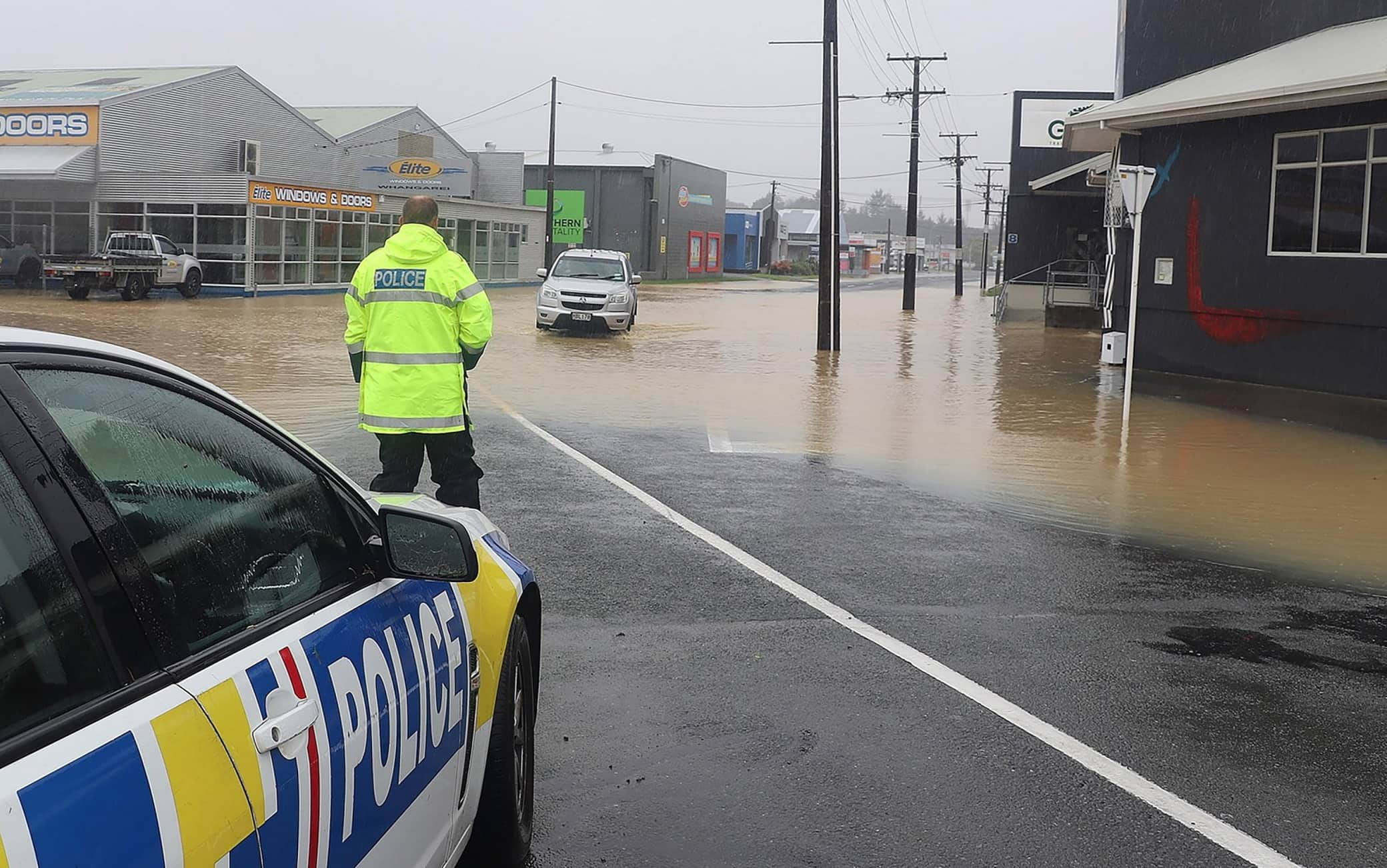 epa10465753 A handout photo made available by the New Zealand Police assisting motorists around flood waters in Whang?rei, New Zealand, issued 13 February 2023. The New Zealand government is considering a national state of emergency, with tens of thousands of homes without power and Cyclone Gabrielle's worst still to come as the storm surges south.  EPA/NEW ZEALAND POLICE HANDOUT AUSTRALIA AND NEW ZEALAND OUT HANDOUT EDITORIAL USE ONLY/NO SALES/NO ARCHIVES