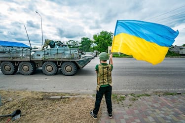 A boy waves a Ukrainian flag as an armored vehicle from the Ukrainian army goes to the Bakhmut frontlines,  In Sloviansk, on june 27, 2023. (Photo by Celestino Arce/NurPhoto via Getty Images)