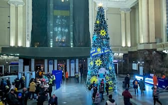 People are standing by the Christmas tree at the Central Railway Station in Kyiv, Ukraine, on December 21, 2023, where the presentation of the ''Star is Rising'' exhibition is taking place. (Photo by Ukrinform/NurPhoto via Getty Images)