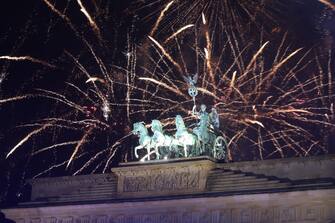 epa11051447 Fireworks illuminate the sky over the Quadriga statue of the Brandenburg Gate during New Year's Eve celebrations in Berlin, Germany, 01 January 2024.  EPA/CLEMENS BILAN