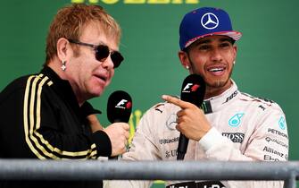 AUSTIN, TX - OCTOBER 25:  Lewis Hamilton of Great Britain and Mercedes GP celebrates on the podium with Elton John after winning the United States Formula One Grand Prix and the championship at Circuit of The Americas on October 25, 2015 in Austin, United States.  (Photo by Lars Baron/Getty Images)