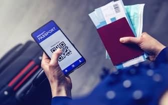 tourist using immunity passport app in mobile phone for travel