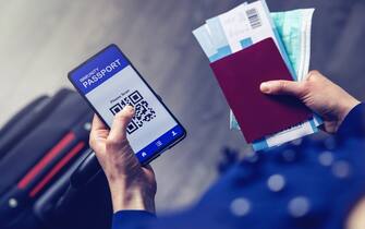 tourist using immunity passport app in mobile phone for travel