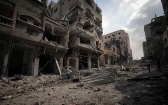 Displaced Palestinians walk among the ruins of buildings hit by Israeli airstrikes in the Jabalia area in the northern Gaza Strip, on October 11, 2023. (Photo by Loay Ayyoub/For The Washington Post via Getty Images)