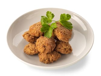 Breaded meatballs fried in white dish with parsley leaves, isolated on white with clipping path