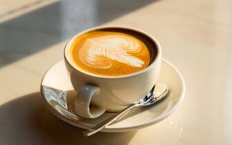 Feshly brewed  latte coffee on a white table, a coffee drink made with espresso and steamed milk.