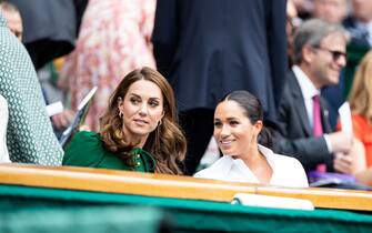 LONDON, ENGLAND - JULY 13: Catherine, Duchess of Cambridge talks with Meghan, Duchess of Sussex in the royal box before the start of the Women's Singles Final between Simona Halep of Romania and Serena Williams of USA (not pictured) at The Wimbledon Lawn Tennis Championship at the All England Lawn and Tennis Club at Wimbledon on July 13, 2019 in London, England. (Photo by Simon Bruty/Anychance/Getty Images)