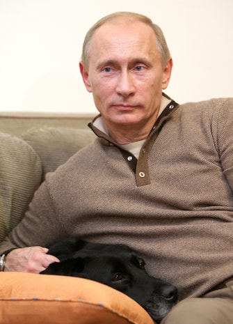 Russian Prime Minister Vladimir Putin sits with his labrador dog Koni at the Novo-Ogaryovo residence outside Moscow on October 16, 2010. Putin and his wife invited a census taker to their suburban residence to fill in the census questionnaire. From October 14 to October 25, about 650,000 census takers are to canvas Russia asking people over a dozen questions about their household, birthplace, nationality and other personal details in the first census since 2002.AFP PHOTO/ RIA-NOVOSTI POOL/ ALEXEY DRUZHININ (Photo credit should read ALEXEY DRUZHININ/AFP via Getty Images)