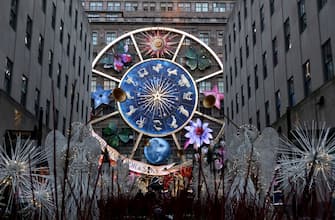 NEW YORK, NY - NOVEMBER 30: People walk through Rockefeller Center Plaza in front of the Christmas decorations on the facade of the Saks Fifth Avenue store on Fifth Avenue on November 30, 2023, in New York City. (Photo by Gary Hershorn/Getty Images)