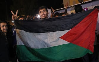 Persone festeggiano in strada a Gaza per l'accordo fra Israele e Hamas People celebrate along a street in Khan Yunis in the southern Gaza Strip on January 15, 2025, amid the ongoing war in the Palestinian territory between Israel and Hamas. Thousands of Gazans celebrated on January 15 as news spread that a ceasefire and hostage release deal had been reached between Israel and Hamas, aimed at ending more than 15 months of war in the Palestinian territory. (Photo by BASHAR TALEB / AFP)