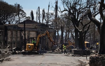 epa10796016 Workers clean the streets after a wild fire swept through the city of Lahaina only leaving ruins, Hawaii, USA, 11 August 2023. At least 67 people were killed in the wildfires burning in Maui, which is considered the largest natural disaster in Hawaii's state history.  EPA/ETIENNE LAURENT