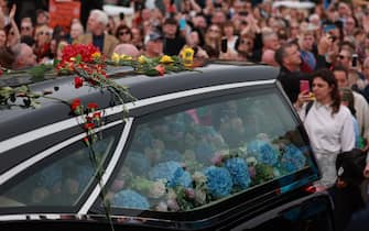 Fans of singer Sinead O'Connor line the streets for a "last goodbye" to the Irish singer as her funeral cortege passes through her former hometown of Bray, Co Wicklow, ahead of a private burial service. Picture date: Tuesday August 8, 2023.