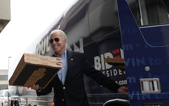 Democratic presidential candidate former Vice President Joe Biden carries a pizza box before speaking at a stop event in Des Moines, Iowa on February 3, 2020. - Voting in tonight's Iowa caucuses kicks off the presidential nominating season across the United States, and voters need to arrive on time if they want to take part. (Photo by Kerem Yucel / AFP) (Photo by KEREM YUCEL/AFP via Getty Images)