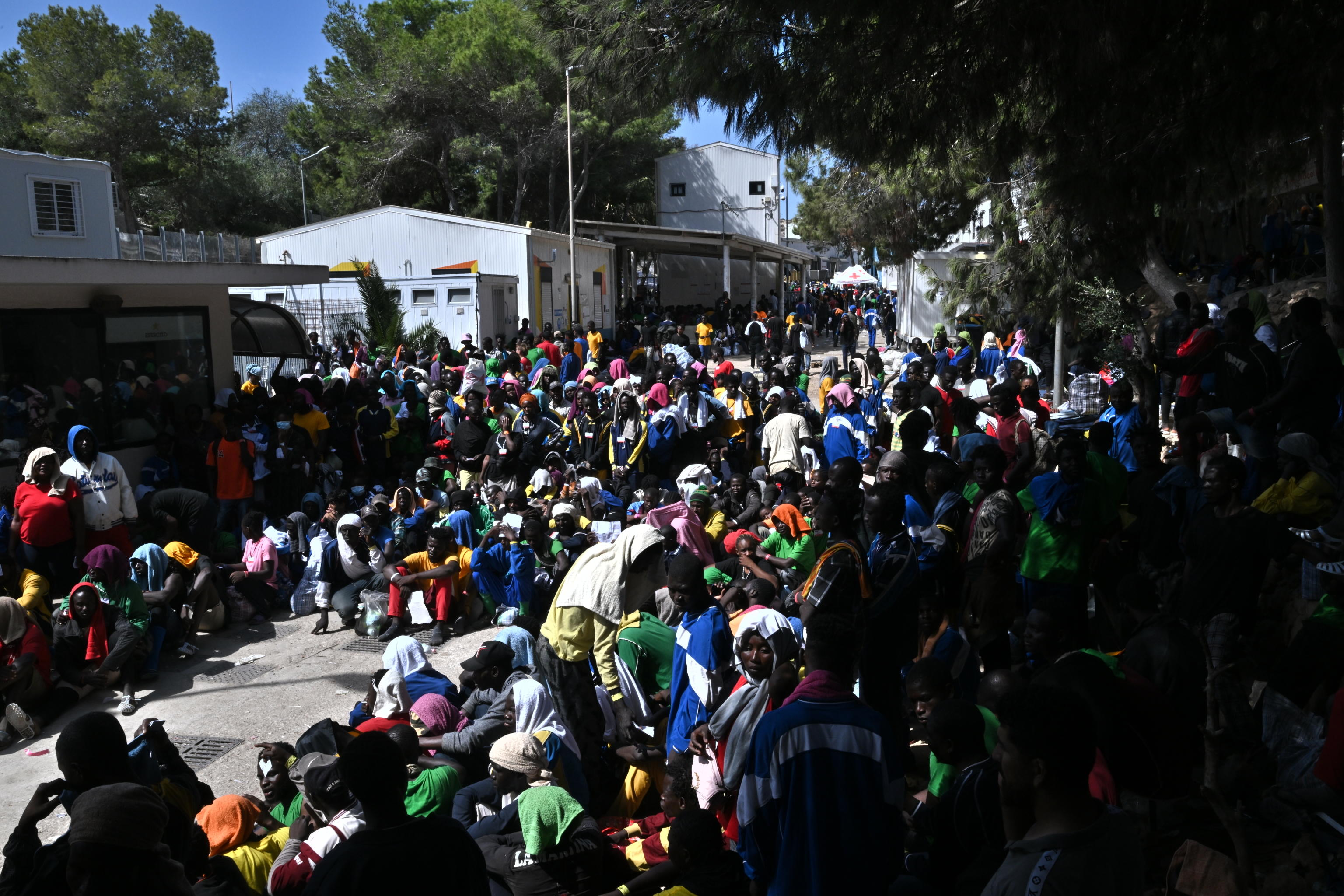 Migrants wait in line outside the hotspot to be transferred to other places from the Lampedusa's island southern Italy, 15 September 2023. A record number of migrants and refugees have arrived on the Italian island of Lampedusa in recent days. Lampedusa's city council declared a state of emergency on 13 September evening after a 48-hour continuous influx of migrants. In the morning of September 14, nearly 7,000 migrants were on the island. 
ANSA/CIRO FUSCO