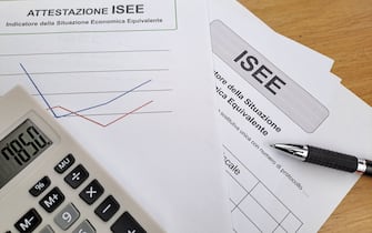 Equivalent Economic Situation Indicator Form Modello ISEE. On the table pen and calculator.