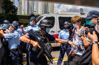 HONG KONG, CHINA - JULY 06: Police stand guard as defendant Tong Ying-kit, 23, arrives the court - Tong accused of deliberately driving his motorcycle into a group of police officers, is the first person charged for incitement to secession and terrorist activities under the national security law, on July 6, 2020 in Hong Kong, China. (Photo by Billy H.C. Kwok/Getty Images)