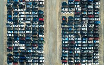 Aerial view of auction reseller company big parking lot with parked cars ready for remarketing services. Sales of secondhand vehicles