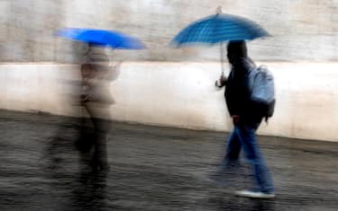 Persone si riparano con lÕombrello dalla pioggia, Roma, 28 novembre 2023. ANSA/ANGELO CARCONI