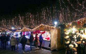 Shoppers and revellers shopping at night at Christmas market in Bruges