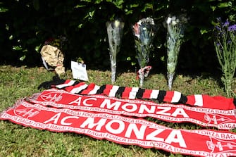 A photo shows flowers and AC Monza football club scarves layed in tribute outside Villa San Martino, the residence of Italian businessman and former prime minister Silvio Berlusconi, following his death, in Arcore, northern Italy, on June 12, 2023. Italy's former prime minister Silvio Berlusconi has died aged 86, his spokesman confirmed to AFP on June 12, 2023. The billionaire media mogul was admitted to a Milan hospital on June 9 for what aides said were pre-planned tests related to his leukemia. (Photo by Piero CRUCIATTI / AFP)