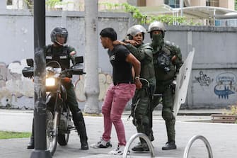 epa11510504 Members of the Bolivarian National Guard (GNB) detain an opposition protester in Caracas, Venezuela, 30 July 2024. Thousands of Venezuelans gathered in Caracas on 30 July in an event called by the majority opposition, to reject for the second consecutive day what they consider to be fraud in the official results of the National Electoral Council (CNE), which proclaimed Nicolas Maduro as re-elected president with 51.2 percent of the votes.  EPA/RONALD PENA R