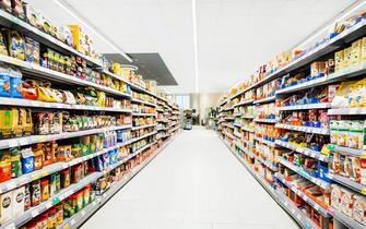 A colorful supermarket aisle withe no people but an abundance of food.