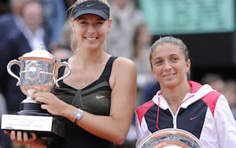epa03256505 Maria Sharapova (L) of Russia and Sara Errani (R) of Italy pose with their trophies after the women's final match for the French Open tennis tournament at Roland Garros in Paris, France, 09 June 2012.  EPA/CHRISTOPHE KARABA