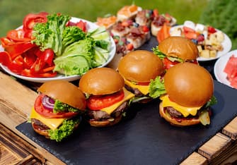 Close-up of burgers on table. Picnic Table Spread