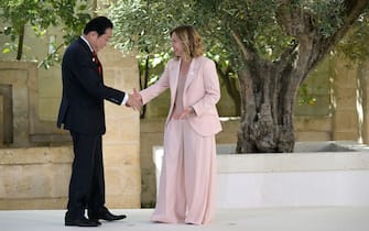 Japanese Prime Minister Fumio Kishida is welcomed by Italy's Prime Minister Giorgia Meloni upon arrival at the Borgo Egnazia resort for the G7 Summit hosted by Italy in Apulia region, on June 13, 2024 in Savelletri. Leaders of the G7 wealthy nations gather in southern Italy this week against the backdrop of global and political turmoil, with boosting support for Ukraine top of the agenda. (Photo by Tiziana FABI / AFP)