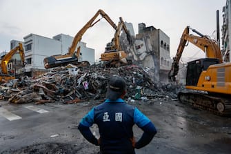 epa11257858 A worker watches excavators demolish the wreckage of a collapsed residential building following the 03 April magnitude 7.4 earthquake in Hualien, Taiwan, 04 April 2024. According to data released by Taiwan's National Fire Agency, the earthquake has taken at least nine lives and injured hundreds, making it the strongest earthquake in 25 years.  EPA/DANIEL CENG