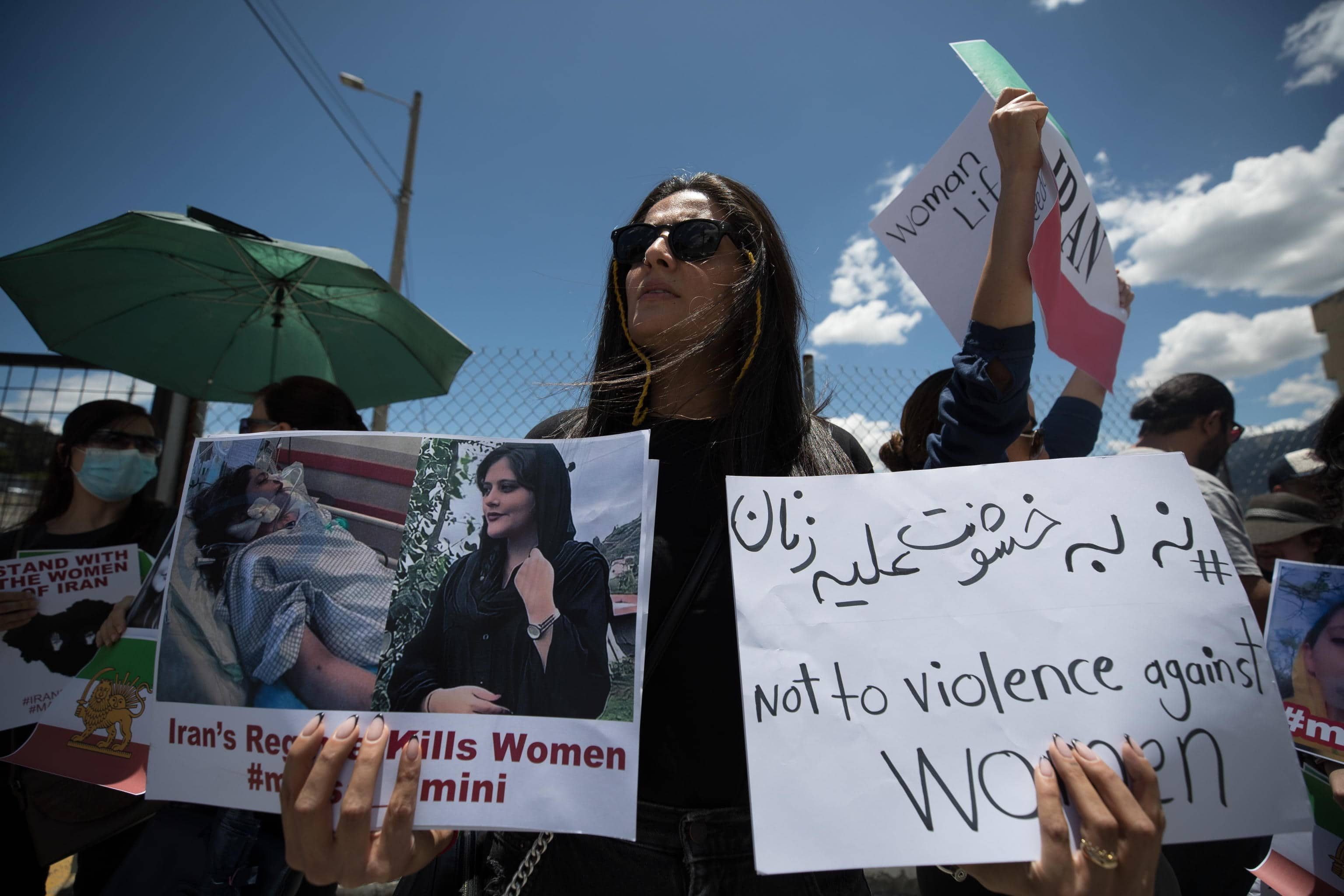 epa10210511 A woman holds two posters against the violence in Iran at a demonstration in Quito, Ecuador, 27 September 2022. The Iranian community residing in Ecuador protested outside the Iranian embassy in Quito against the internet cuts and the Iranian government's repression of the wave of protests over the death of Mahsa Amini, who died after she was arrested by the Iranian Police Moral.  EPA/Jose Jacome