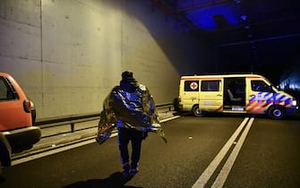 A passenger covered with an emergency blanket walks near an ambulance after a rail accident involving a collision between a cargo and a passenger train in the Evangelismos area of Larissa, Greece on March 1, 2023. (Photo by STRINGER / SOOC / SOOC via AFP) (Photo by STRINGER/SOOC/AFP via Getty Images)