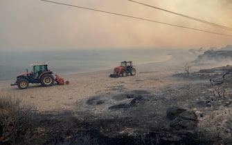 epaselect epa10762717 ?ractors operate during a wildfire in Kiotari village, on Rhodes island, Greece, 22 July 2023. Although the Fire Department had managed to put out several rekindled blazes on the island over the last few days, the wildfire near the village of Laerma in the island's north keeps expanding and moving eastwards to the Gadoura dam, while residents in the villages of Lardos and Pilonas were told to evacuated their homes on the day, via the emergency number 112. Some 173 firefighters with 35 fire engines and 10 ground teams are battling the blaze, assisted by 3 water bombers and 2 helicopters. Another 31 firefighters with 4 fire engines and 3 ground teams were also expected to arrive from Slovakia. Local authority water tanks are also helping out.  EPA/DAMIANIDIS LEFTERIS