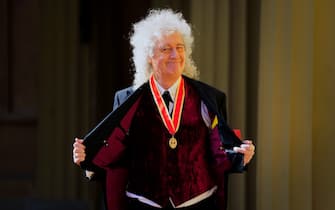 Brian May dopo la cerimonia di cavalierato mostra la medaglia