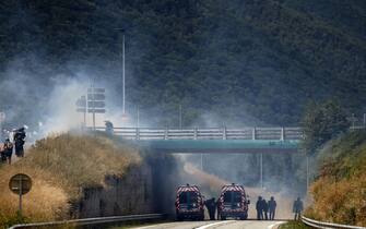 Gendarmes stand near tear gas smoke during clashes with protesters during a demonstration against the construction of a high-speed rail line between Lyon and Torino, in La Chapelle, near Modane, in the French Alps' Maurienne valley, on June 17, 2023. Hundreds of oponents to the Lyon-Torino high-speed rail line demonstrated on June 17 despite a ban on the gathering, of which the details are yet to be determined and despite a heavy police presence in the valley. They set up a makeshift camp on land lent by the municipality of La Chapelle, outside the ban zone announced the day before by the Savoie prefecture. (Photo by OLIVIER CHASSIGNOLE / AFP) (Photo by OLIVIER CHASSIGNOLE/AFP via Getty Images)