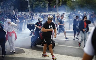 epa10717462 People run from tear gas during clashes with French riot police on the sidelines of a march in the memory of 17-year-old Nahel, who was killed by French Police in Nanterre, near Paris, France, 29 June 2023. Violence broke out after the police fatally shot a 17-year-old during a traffic stop in Nanterre on 27 June. According to the French interior minister, 31 people were arrested with 2,000 officers being deployed to prevent further violence.  EPA/YOAN VALAT