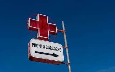 Italy - January 03, 2023: Italian first aid sign with red cross on blue sky, tex: Pronto Soccorso (first aid), copy space
