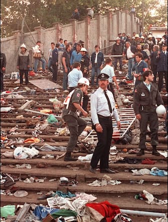 Rescuers search for victims on May 29, 1985 at the scene of riots in Heysel football stadium in Brussels after thirty-nine fans died during violences at the European Cup Final in Brussels. Shortly before kick off the atmosphere turned violent and Liverpool supporters stampeded through a thin line of police towards the rival fans. As the Juventus fans retreated a wall collapsed under the pressure and fans were crushed and trampled to death in the panic. AFP PHOTO DOMINIQUE FAGET (Photo by DOMINIQUE FAGET / AFP) (Photo by DOMINIQUE FAGET/AFP via Getty Images)