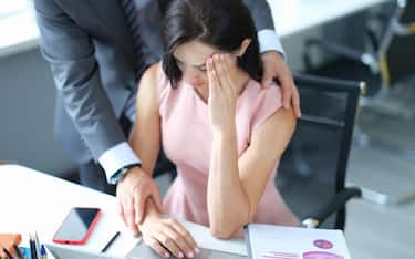 Businessman pestering female colleague in the workplace. Harassment at work concept