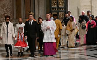 The first pilgrims pass the Holy Door of St Peter's Basilica in the Vatican during a ceremony to mark the start of the Catholic Jubilee Year, on December 24, 2024. - Pope Francis marks Christmas Eve with a special ceremony launching Jubilee 2025, a year of Catholic celebrations set to draw more than 30 million pilgrims to Rome. Over the next 12 months, pilgrims will pass through the large and imposing bronze door, which is normally closed, by tradition benefiting from a "plenary indulgence", a type of forgiveness for their sins. (Photo by Alberto PIZZOLI / POOL / AFP)