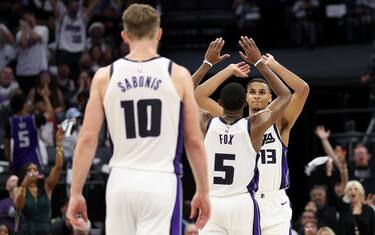 SACRAMENTO, CALIFORNIA - APRIL 16: Keegan Murray #13 of the Sacramento Kings is congratulated by De'Aaron Fox #5 and Domantas Sabonis #10 of the Sacramento Kings during their game against the Golden State Warriors in the second half during the Play-In Tournament at Golden 1 Center on April 16, 2024 in Sacramento, California.  NOTE TO USER: User expressly acknowledges and agrees that, by downloading and or using this photograph, User is consenting to the terms and conditions of the Getty Images License Agreement.  (Photo by Ezra Shaw/Getty Images)