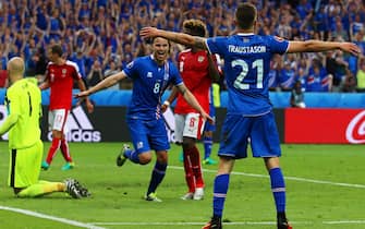 epa05384277 Arnor Ingvi Traustason (R) of Iceland celebrates with his teammate Birkir Bjarnason (C) after scoring the winning goal during the UEFA EURO 2016 group F preliminary round match between Iceland and Austria at Stade de France in Saint-Denis, France, 22 June 2016. Iceland won 2-1.

(RESTRICTIONS APPLY: For editorial news reporting purposes only. Not used for commercial or marketing purposes without prior written approval of UEFA. Images must appear as still images and must not emulate match action video footage. Photographs published in online publications (whether via the Internet or otherwise) shall have an interval of at least 20 seconds between the posting.)  EPA/SRDJAN SUKI   EDITORIAL USE ONLY
