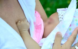 Una mamma allatta il suo neonato